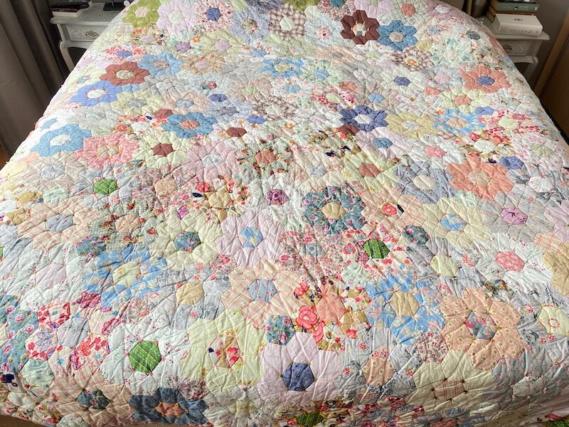 Grote bloemenquilt op bed